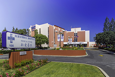 Picture of exterior of Alhambra Hospital Medical Center with the Hospital sign in front of it.
