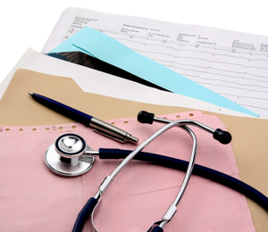 Picture of a stethoscope and a pen on top of a stack of papers.

