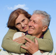 Picture of an older couple hugging and smiling.
