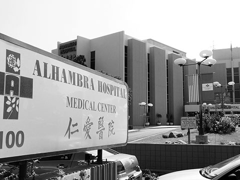 Picture of exterior of Alhambra Hospital Medical Center and the Hospital sign in front of the Hospital.
