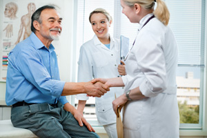Picture of a female Physician shaking a male patient's hand.