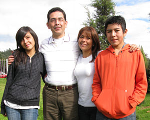 Picture of a family of four. There is a father, mother, and their teenage daughter and son.
